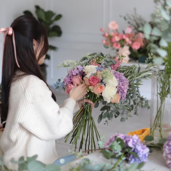 A guest creating a hand-tied floral bouquet